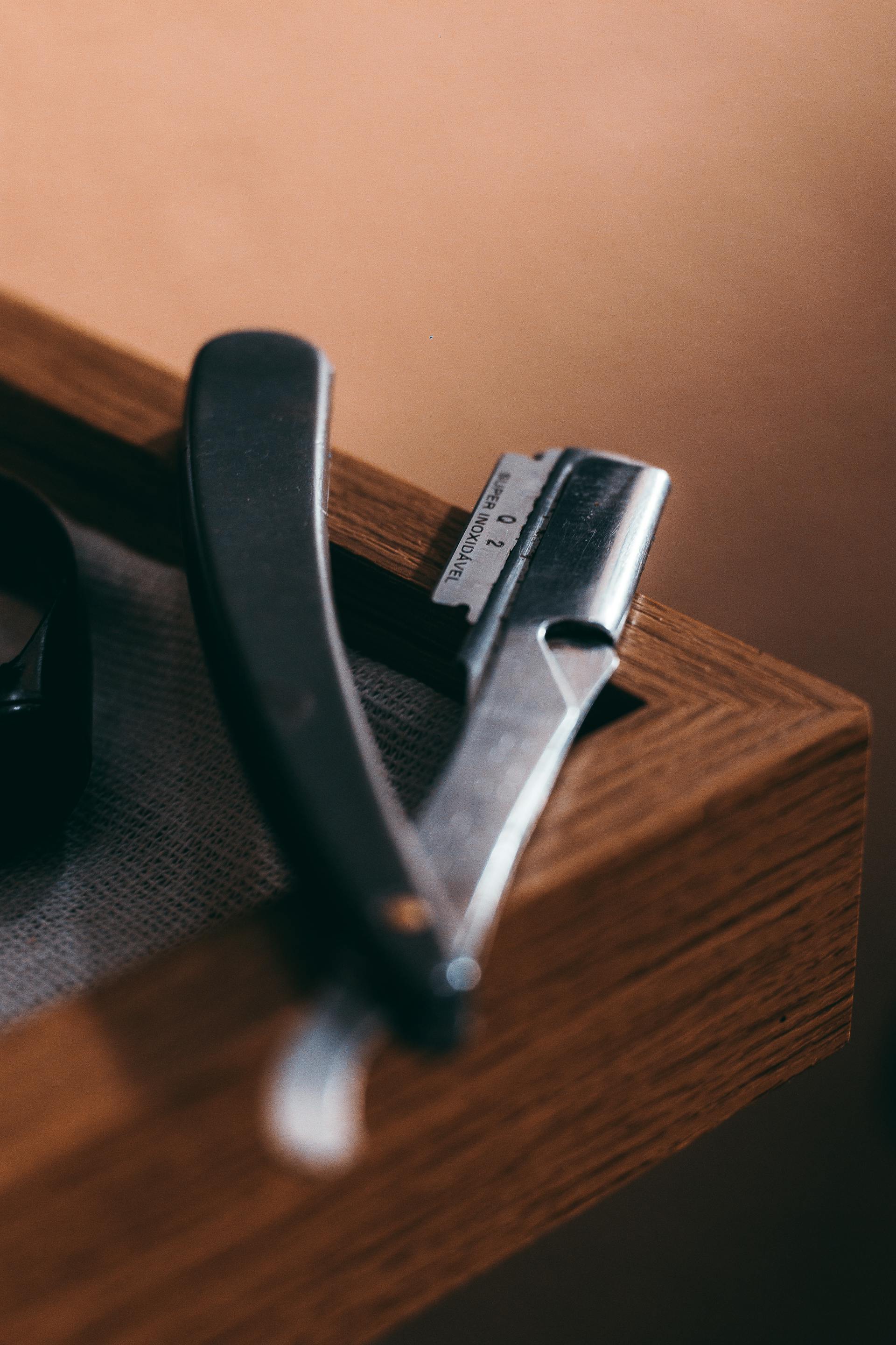 Straight razor on dark wood — house signature